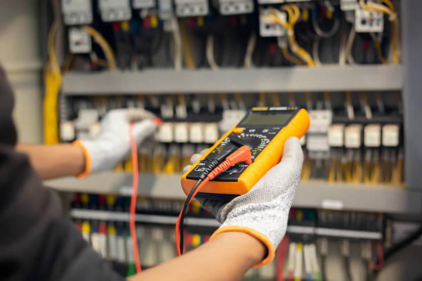 Electrician testing a consumer unit with a multimeter
